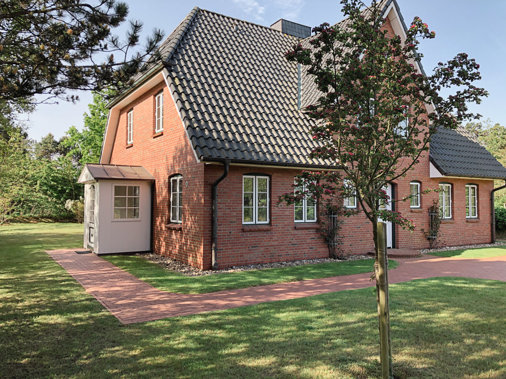 Ferienhaus Classic – Seitliche Hausansicht mit Eingang und Garten