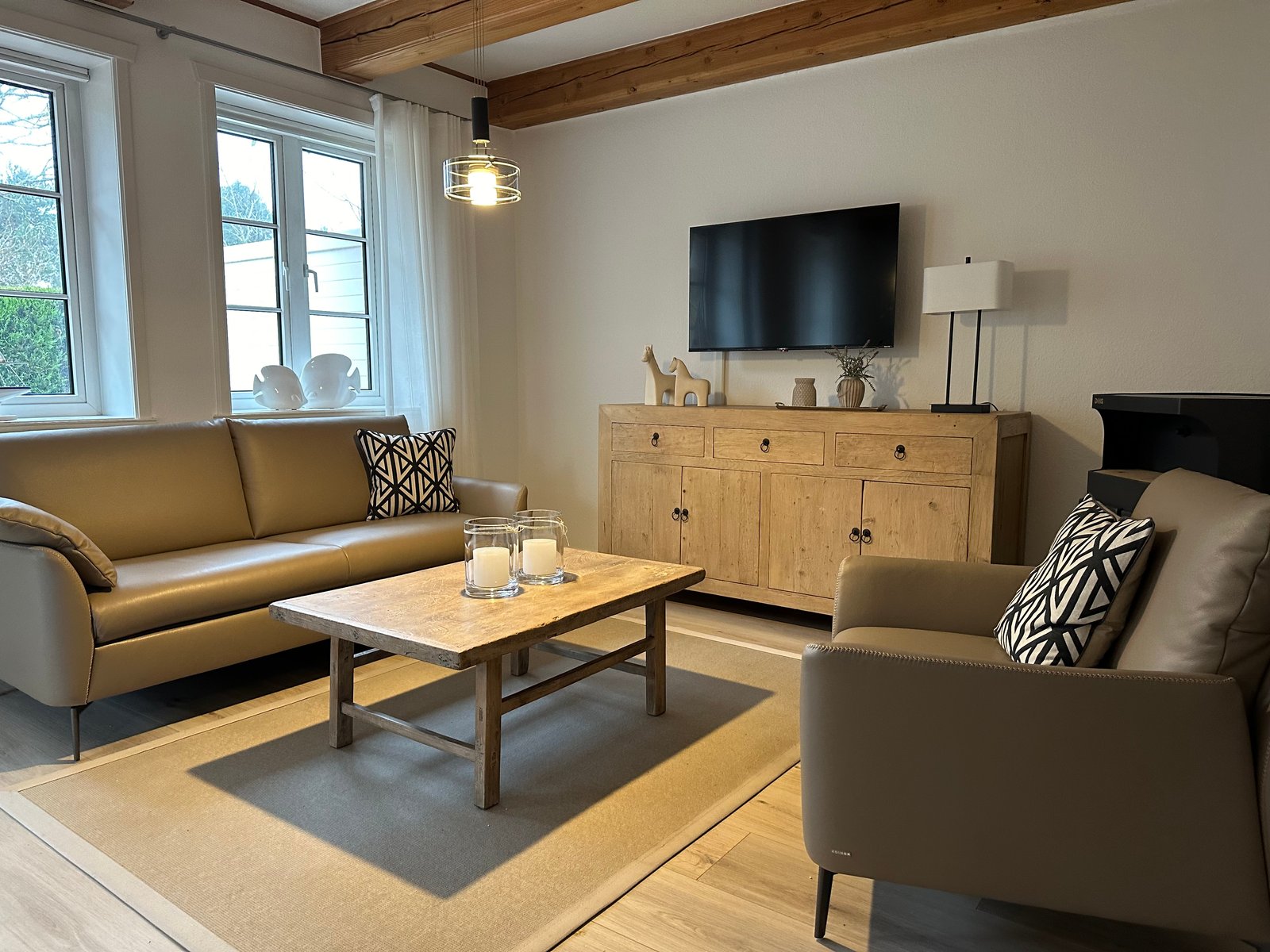 Ferienhaus Classic – Wohnzimmer mit Sofa, Sessel und Fernseher